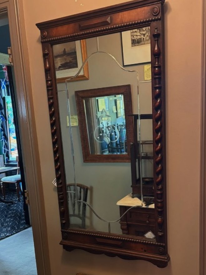 Tall walnut pier mirror with barley-twist turned columns down each side, a beaded cornice with rosette corner blocks, and a shaped shelf across the base.