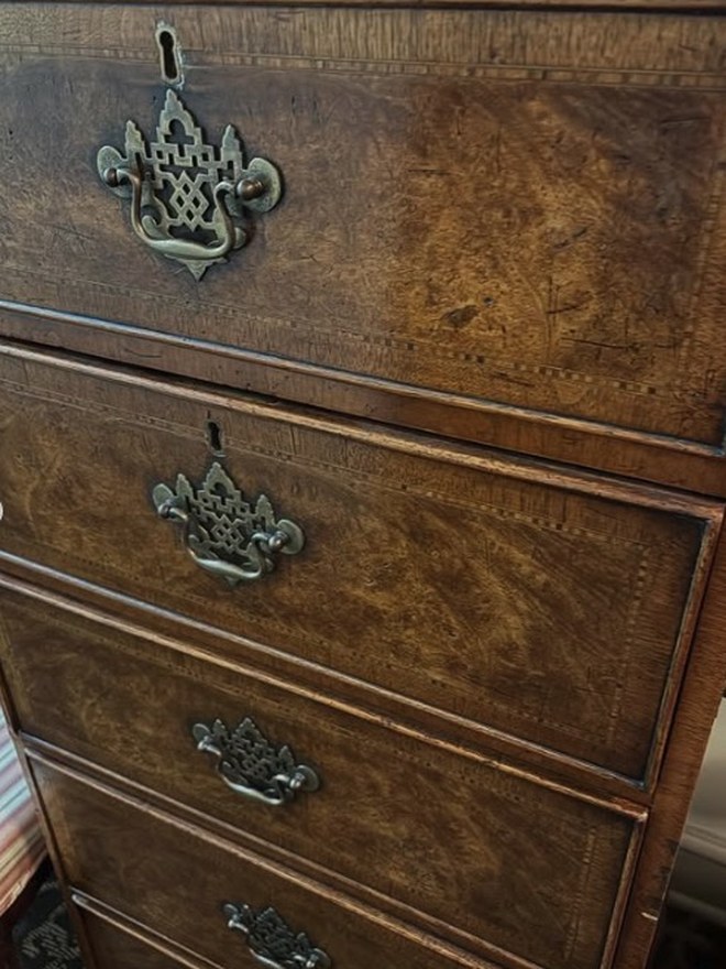 English burl-walnut gentleman's dresser with inlaid stringing on the drawers and pierced brass batwing handles.