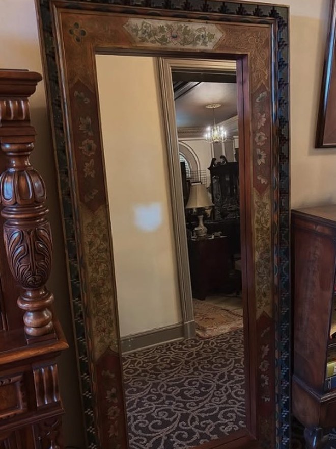 Tall floor mirror in a mahogany frame with hand-painted floral panels and an inlaid diamond-pattern border.