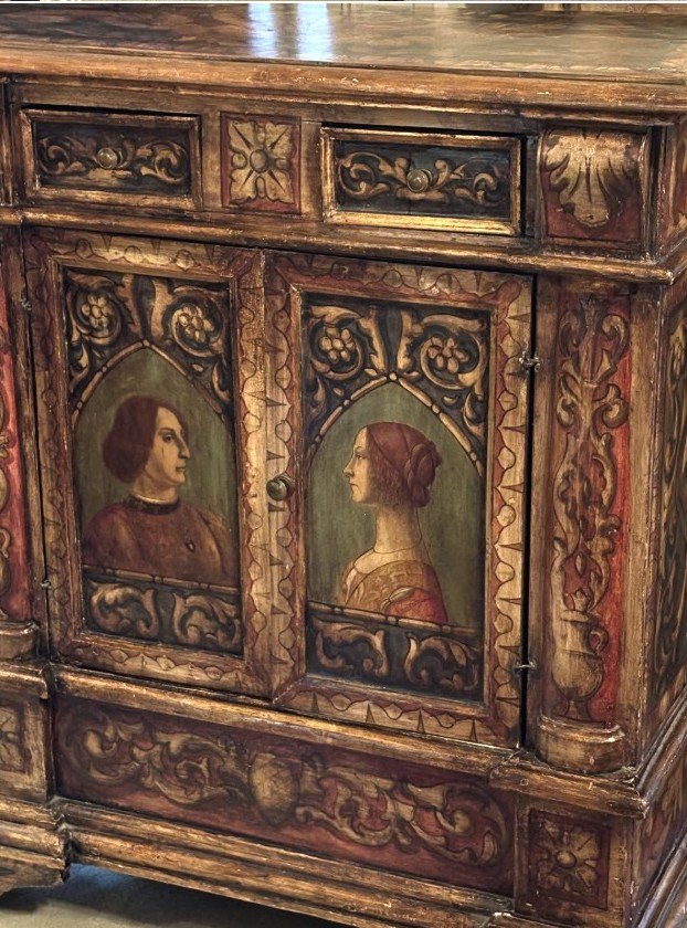 Renaissance-style cabinet with carved, polychrome panels and twin painted portraits of a man and a woman.