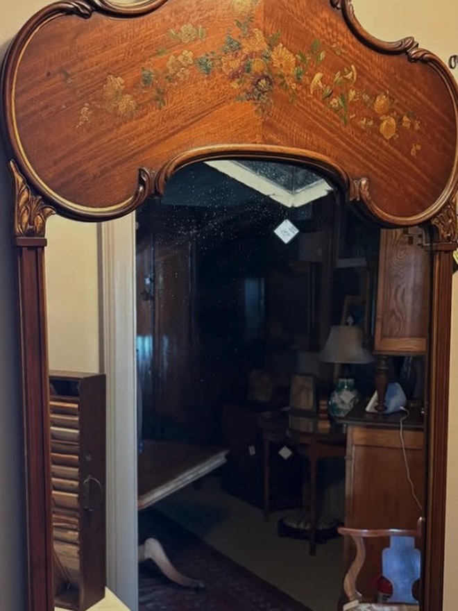 Satinwood mirror with a shaped serpentine crest, a hand-painted floral spray across the top, gilt acanthus corners, and reeded pilasters.
